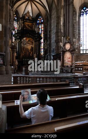 Lone man praying inside St. Stephen's cathedral or Stephansdom in Vienna, Austria, Europe. People and religion in catholic church in Wien Stock Photo