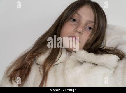 Young girl with brown/blonde hair and  green eyes wearing a fur coat Stock Photo