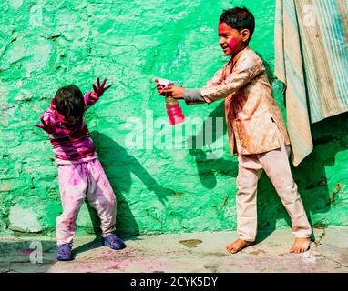 Nandgeon, India, Holi Festival, Feb 25, 2018 - Boy sprays his brother with color water during Festival of Colors in India Stock Photo