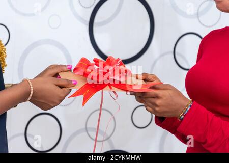 black woman receiving a gift from a friend Stock Photo