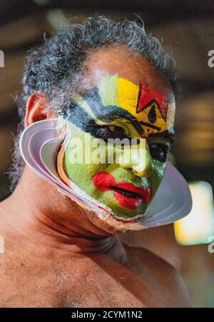 Munnar, India, Mar 11, 2018 - Traditional Indian dancer applies paint to his face prior to show Stock Photo