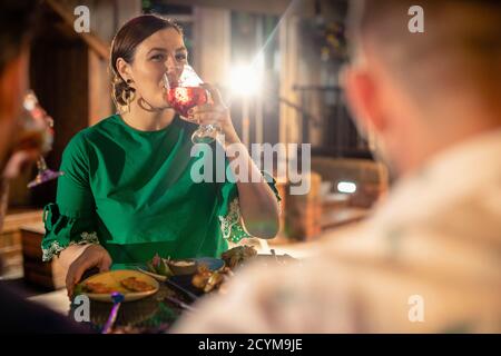 Friends drinking alcohol outdoors at a bar/restaurant, celebrating and having fun together. Stock Photo