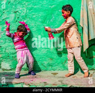 Nandgeon, India, Holi Festival, Feb 25, 2018 - Boy sprays his brother with color water during Festival of Colors in India Stock Photo