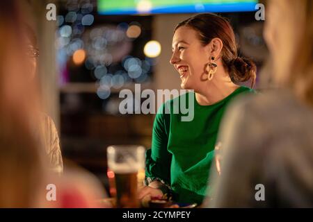 Group of friends drinking alcoholic drinks outdoors at a bar/restaurant, celebrating and having fun together. Stock Photo