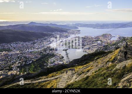 People hike Ulriken mountain trail overlooking city of Bergen, Norway. At 643 meters, Ulriken is the highest of Seven Mountains surrounding Bergen. Stock Photo