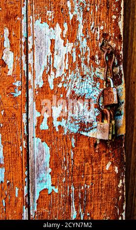 Peeling painted fence with rusted lock old Stock Photo