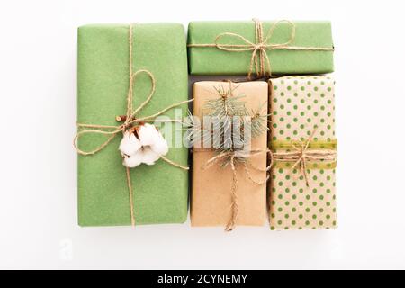 Christmas composition made of presents decorated with fir tree branches, cotton on white wooden background, table. Christmas, Xmas, winter, new year Stock Photo