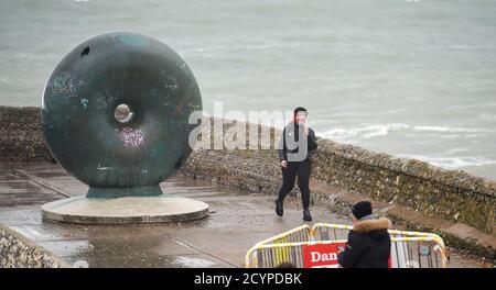 Brighton UK 2nd October 2020 - A young woman laughs after getting wet  as waves crash in on Brighton seafront as Storm Alex sweeps across Britain bringing strong winds and rain especially in southern areas  : Credit Simon Dack / Alamy Live News Stock Photo