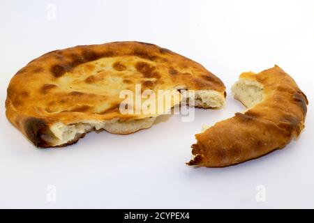 Caucasian unleavened white bread made from wheat flour - pita bread - on a white background, with a broken off piece Stock Photo
