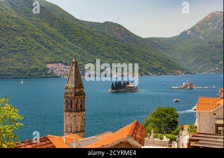 View looking out over the Bay of Kotor from above Perast, Montenegro. With the bell tower of St Nicholas and the islets of Lady of the Rocks and Saint Stock Photo