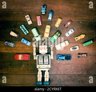 retro  toy robot from above surounded by toy cars Stock Photo