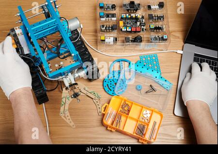 Stem school theme. Student programming robot bot with laptop Stock Photo