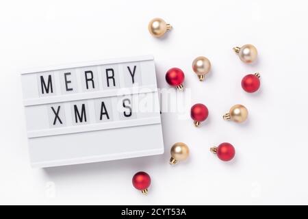Lightbox with text MERRY XMAS and golden and red christmas balls on white background. Christmas composition - Image Stock Photo
