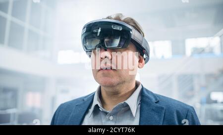 Female Engineer Using Augmented Reality Headset. and Moving Virtual Pieces in the Air. In Innovation High Tech Laboratory Facility with Futuristic Stock Photo