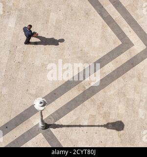 a gentleman walks on the main square of the town on a sunny summer day Stock Photo