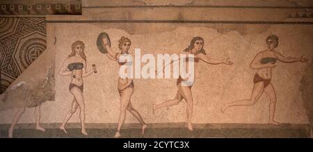 The upper register of the famous 'Room of the women in Bikinis' at the Roman villa in Piazza Armerina, showing the original floor mosaic underneath. Stock Photo