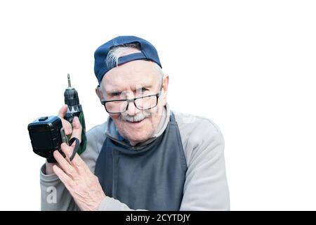 Happy old man posing with an electric screwdriver, smiling. Old farmer with a drill. Isolated on a white background Stock Photo
