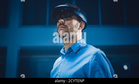 In 3D Content Creating Laboratory Engineer Wearing Professional Virtual Reality Headset and Works in Augmented Reality. Stylish Low Angle Portrait Stock Photo
