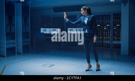 In Modern Data Center Research Laboratory Beautiful Confident Woman Does Virtual Reality Activating Touch Gesture. Mock-up Augmented Reality Shot. Stock Photo