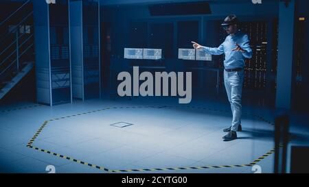 In 3D Content Creating Laboratory Engineer Wearing Professional Virtual Reality Headset Works and Gestures in Augmented Reality. Industrial Software Stock Photo