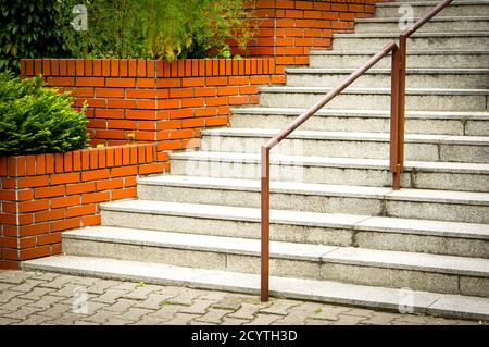 Bunch of gray stairs near brick layers with plants Stock Photo