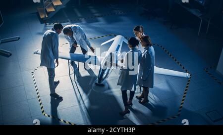 Meeting of Aerospace Engineers Work On Unmanned Aerial Vehicle Drone Prototype. Aviation Scientists in White Coats Talking. Industrial Laboratory with Stock Photo