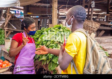 african woman wearing a face mask refuses to shake hands with someone Stock Photo