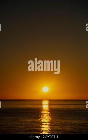 Sun setting over the sea Stock Photo