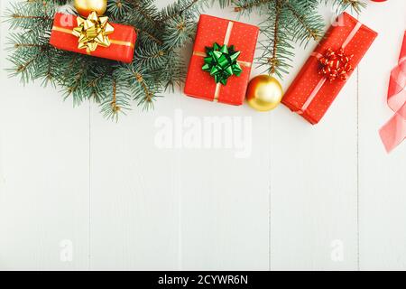 Xmas New Year 2020 holiday celebration pattern composition made of red present gift boxes, fir branches, balls on white wooden background.Concept Chri Stock Photo