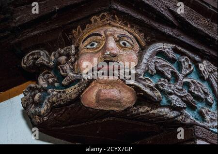 Pride, one of Christianity’s Seven Deadly Sins, represented as a crowned Green Man with foliage flowing from his mouth, in the sculpted end of a wooden ceiling beam protruding from the timber-framed Haus der Sieben Laster (House of the Seven Vices) at Brückengasse 9 in Limburg an der Lahn, Hesse, Germany.  The ancient house, rebuilt in 1567, served as a family home, a provisions shop, an ironmongery and a shoe shop before being renovated in the modern era and opened to the public as a museum. Stock Photo