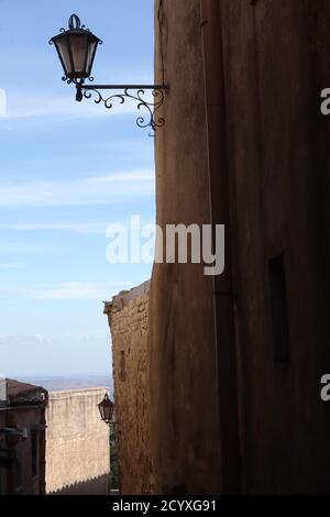 Spectacular view through stone buildings and cobbled streets of valley beyond Erice, Sicily Stock Photo