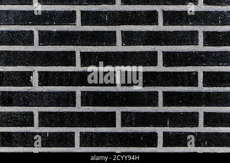 The black glossy brick wall of a modern apartment building. Modern nordic architecture. Pattern of brick wall. Stock Photo