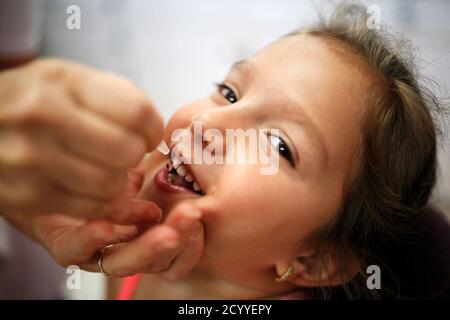 An Israeli child receives a polio vaccine as part the government's immunisation campaign against the disease in the southern city of Beersheba August 5, 2013. Israel said on Sunday it was launching the campaign to administer the active polio vaccine to children in its southern region after tests detected at least 1,000 carriers of the virus in that area, though none were found to be ill with the disease. The Health Ministry said it was recommending that children born after January 2004, but not younger than two months, report to publicly-funded clinics to be administered oral drops of a weaken