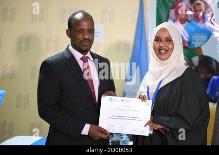 The Somali Federal Minister of Defence, Hassan Ali Mohamed, hands a certificate to a female Somali National Army (SNA) officer at the end of a five-day training on Human Rights and Child Protection in Mogadishu on 17 October 2019. The training was organised and supported by the African Union Mission in Somalia (AMISOM) and the Romeo Dallaire Child Soldiers Initiative. Stock Photo