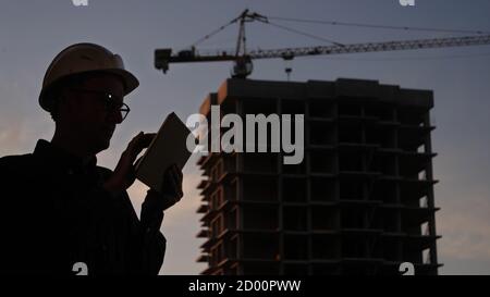 Construction manager using tablet on building site. Stock Photo