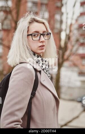 sad young woman in eyeglasses at old autumn park looking aside Stock Photo
