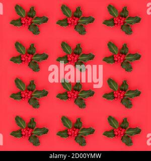 Winter holly berry repeat pattern on red background. Festive composition for wrapping paper or Xmas greetings card. Stock Photo