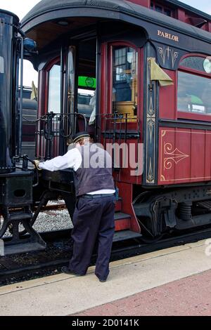 conductor, standing on platform, by parlor car, transportation, old train, visitor rides, Strasburg Rail Road, Lancaster County; Pennsylvania; Ronks; Stock Photo