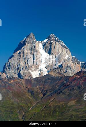 The twin peaks of Mount Ushba (4710m) in the Svaneti region of the Caucasus Mountains in northwestern Georgia. Stock Photo