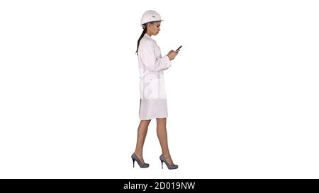 Engineer using mobile phone texting while walking on white backg Stock Photo