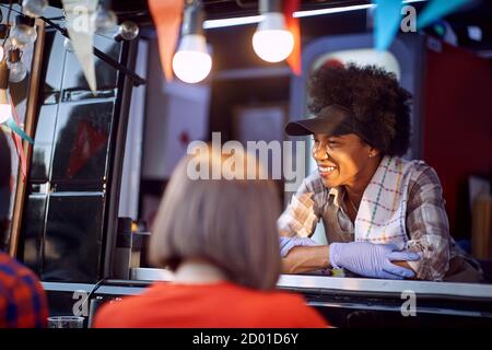 Afro american food truck employee taking orders from customers Stock Photo