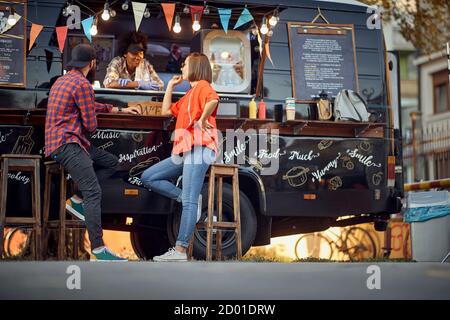 Afro american food truck employee taking orders from customers Stock Photo