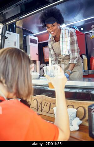 Afro american food truck employee taking orders from customers Stock Photo