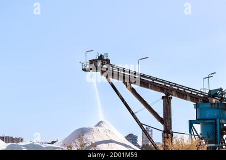 Salt production, conveyor belt with marine salt produced by the evaporation of seawater. Stock Photo