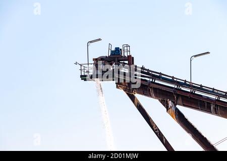 Salt production, conveyor belt with marine salt produced by the evaporation of seawater. Stock Photo