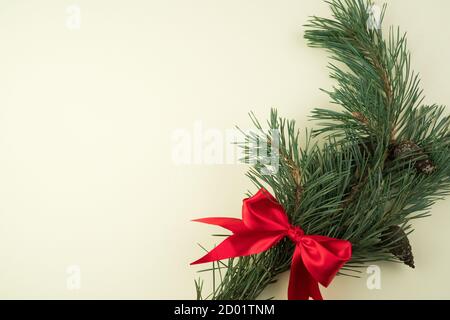 Happy new year 2021 and merry Christmas, a Pine branch with a satin red bow on a concrete salad background. The view from the top. Stock Photo