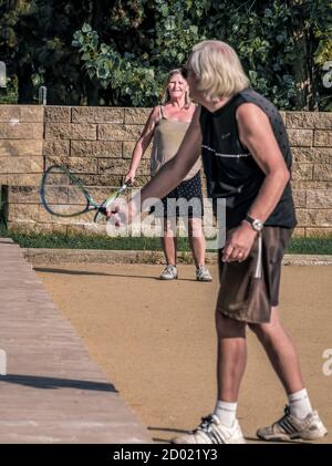 Bucharest/Romania - 09.19.2020: Old couple playing tennis in the park. Selectiv focus on the lady in the background. Stock Photo