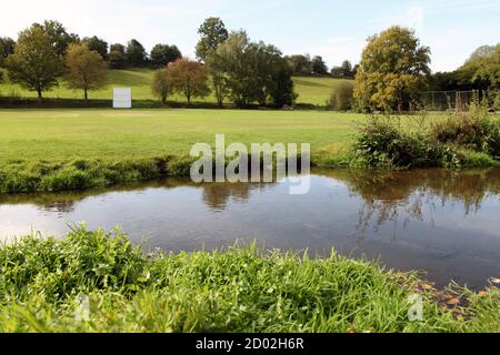 The River Tillingbourne flows past Abinger Hammer village green and cricket ground in the Surrey Hills, Surrey, UK, September 2020 Stock Photo