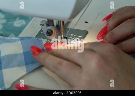 Wickford, Essex, England, September 12th 2020, close up shot of a sewing machine being used with the hands of a young woman operating the machine. Stock Photo