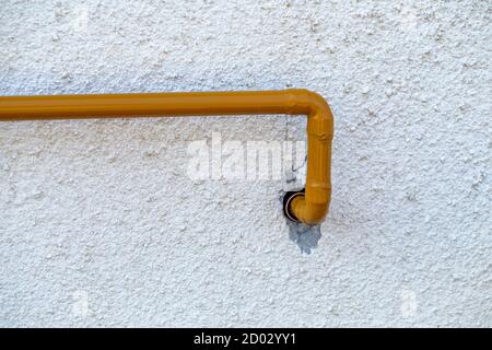 Domestic yellow gas pipe in front of house wall. Stock Photo